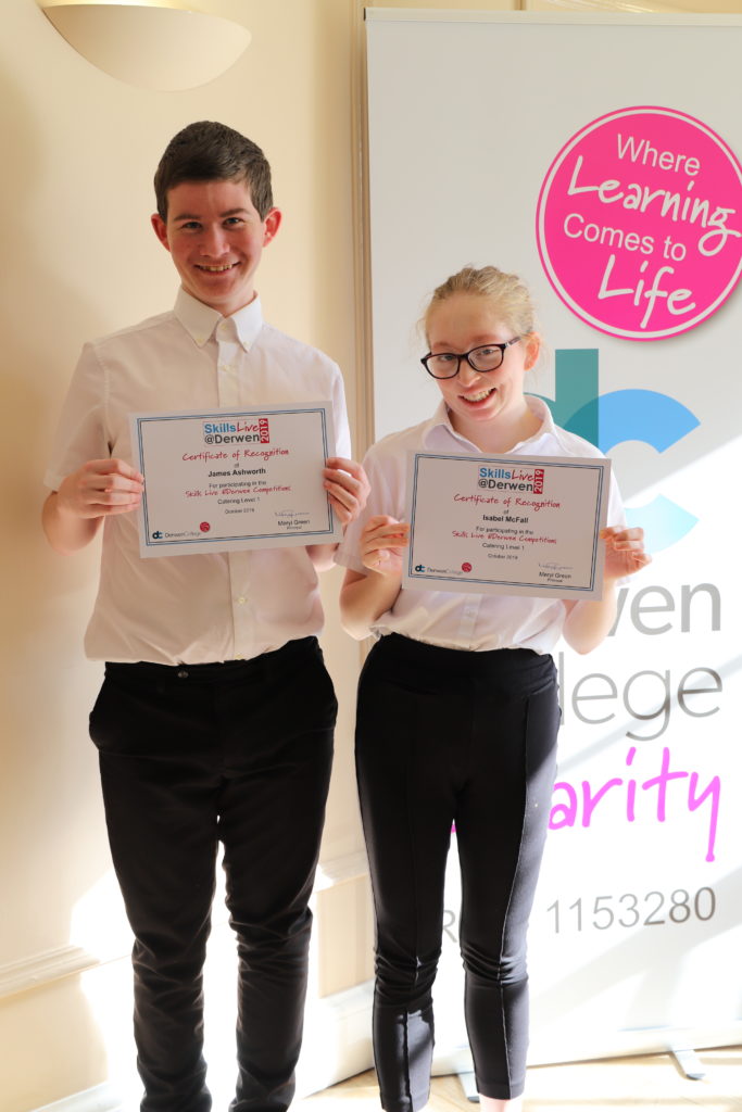 Two catering students with their certificates of recognition